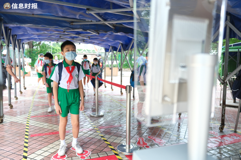 荔湾区坑口小学学生进校门时需经过体温检测，学生分列有序排队，每人保持1米距离。.jpg