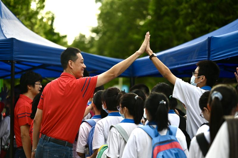 广州大学附属中学老师和考生击掌加油。.png